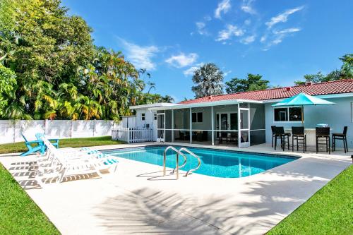 a swimming pool with chairs and a house at Luxury 5BR Villa Heated Pool near Beach & Casino in Dania Beach