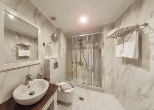 a bathroom with a sink and a shower and a toilet at Karras Hotel in Laganas
