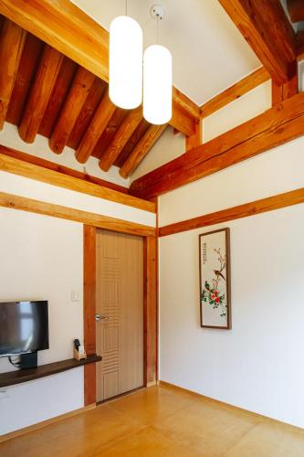 a living room with wooden ceilings and a door at Jeonju Hanok village Deoksugung in Jeonju