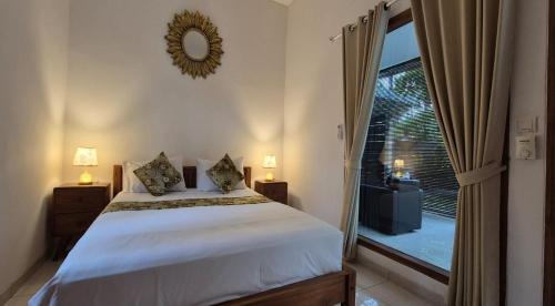 Un dormitorio con una cama y una ventana grande. en Rumah Mimpi Guest House, en Lovina