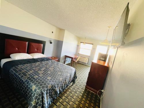 a hotel room with a bed and a desk at Americas Best Value Inn Jay in Jay