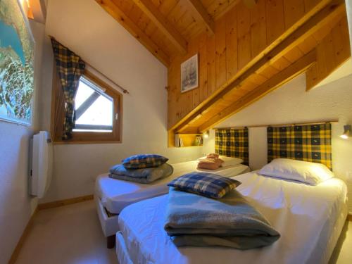 two beds in a room with a attic at Grand T3 lumineux avec balcon, parking & casier skis en centre-ville de Samoëns - FR-1-624-22 in Samoëns