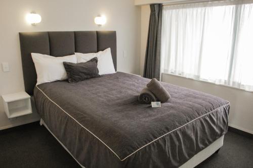 a bedroom with a large bed with two pillows at Anchorage Motor Lodge in Napier