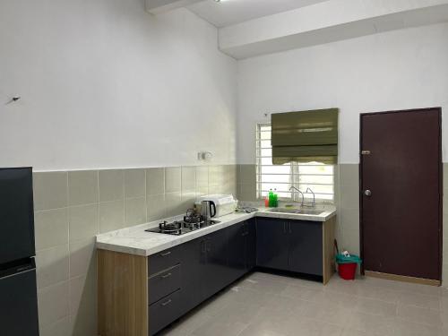 a kitchen with a sink and a stove top oven at LestariHome1, KLIA Sepang in Sepang