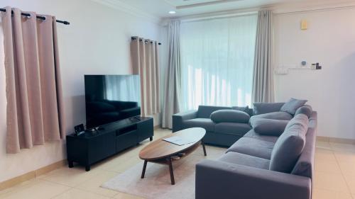 a living room with a couch and a tv at no7 HOMESTAY in Tanjung Karang