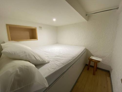 Cette petite chambre comprend un lit blanc et une table. dans l'établissement Studio confortable 4 pers. avec mezzanine et balcon au centre de Cauterets - FR-1-812-112, à Cauterets