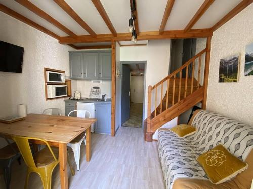 un salon avec une table et un canapé dans l'établissement Studio confortable 4 pers. avec mezzanine et balcon au centre de Cauterets - FR-1-812-112, à Cauterets