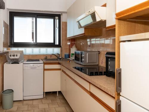 une grande cuisine avec des appareils électroménagers blancs et une fenêtre dans l'établissement Studio cabine au Lavandou, 4 couchages, terrasse, plage à 20m, climatisation - FR-1-803-70, au Lavandou