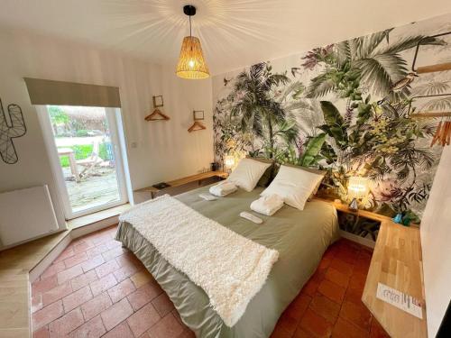 - une chambre avec un grand lit et une plante sur le mur dans l'établissement Gîte de charme avec piscine chauffée, clim et WiFi en Loire - FR-1-381-602, à Savigny-en-véron