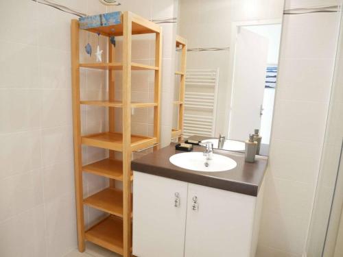 a bathroom with a sink and a wooden shelf at Étel - Appartement cosy 44 m² avec wifi, parking et animaux admis - FR-1-479-182 in Étel
