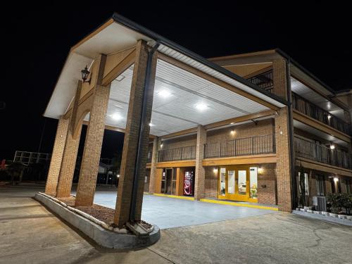 a large brick building at night at American Inn and Suites - Atlanta Airport Jonesboro I-75 in Jonesboro