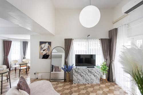 a living room with a television and a couch at Private Pool Villa Resort style, Heart in bkk ,metro,cabaret show,RCA, jodd fair,chatuchak in Bangkok