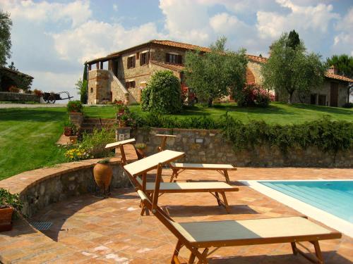 a patio with two picnic tables and a swimming pool at Agriturismo Poggio Istiano in Bagno Vignoni