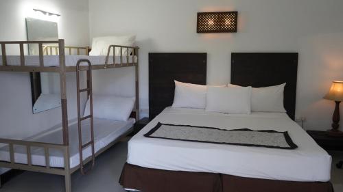 a bedroom with two bunk beds and a mirror at Amaluna Resorts in Negombo