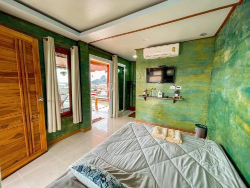 a bedroom with green walls and a bed in it at ระเบียงเลเกาะลิบง โฮมสเตย์ in Ko Libong