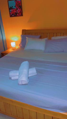 a bed with white sheets and towels on it at Mango Lodge Gambia in Brufut