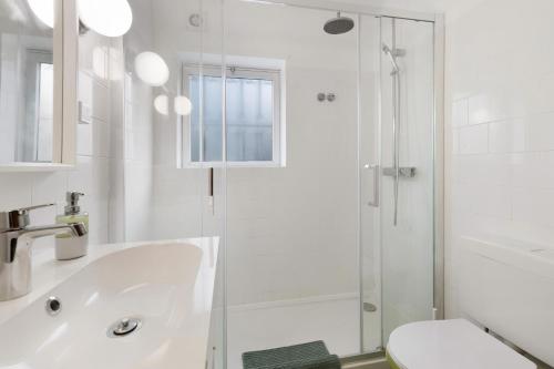 un bagno bianco con lavandino e doccia di Garden House a Cascais