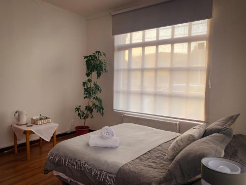 a bedroom with a bed with a towel on it at Patagonia Heritage Home in Punta Arenas