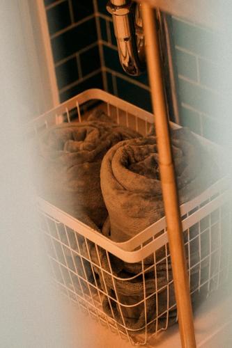 a white laundry basket with a blanket in it at THE ROOT2 HOTEL in Kyoto