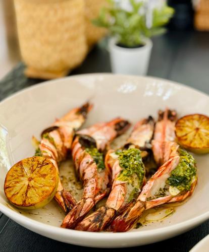 a plate of food with shrimp and vegetables on a table at Three Hearts Guesthouse and Villas in Fulhadhoo