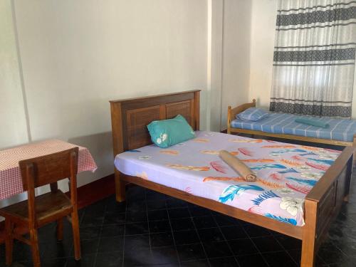 a bedroom with two beds and a table and a table at Jesuit Residence in Galle