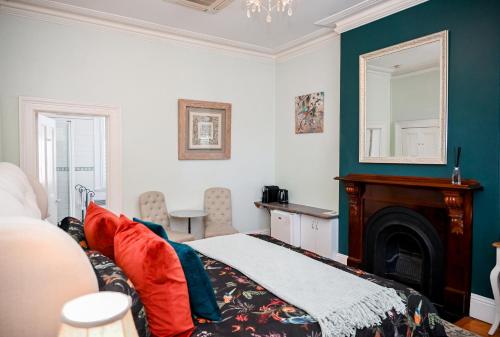 a bedroom with a bed with a fireplace and a mirror at Deck Quarters - Mansfield, Victoria in Mansfield