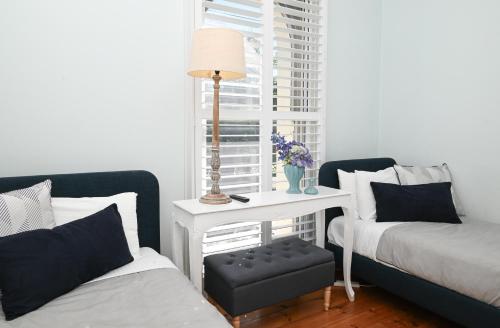 a bedroom with a bed and a table with a lamp at Deck Quarters - Mansfield, Victoria in Mansfield
