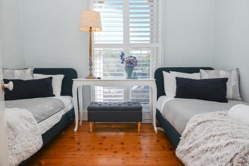 a living room with two beds and a window at Deck Quarters - Mansfield, Victoria in Mansfield