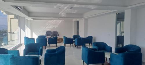 a waiting room with blue chairs and a table at Namami Chail Resort & Spa in Chail
