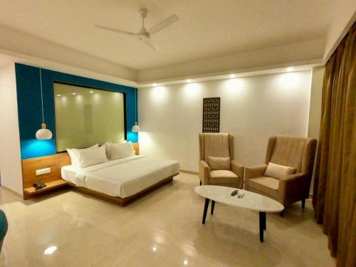 a bedroom with a bed and a table and chairs at Namami Chail Resort & Spa in Chail