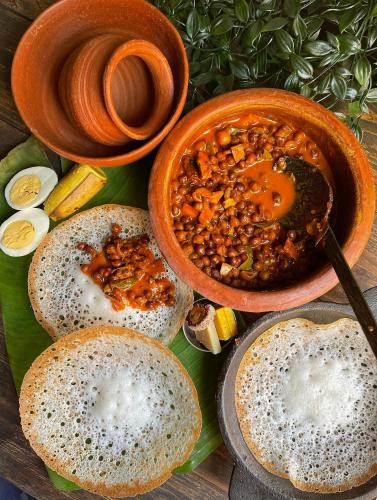 a table with bowls of lentils and a bowl of soup at JoeAnn Villa in Kalpetta
