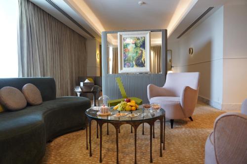 una sala de estar con un sofá y una mesa en The Nishat Hotel, en Lahore