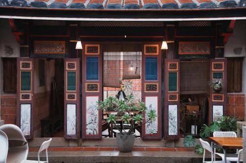 a building with an open door with a plant in front at 序室 Narrative in Jinhu