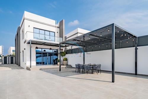 a patio with a table and chairs on a building at Getaway Offer with Pool, BBQ & Picturesque Views by Deluxe Holiday Homes in Fujairah