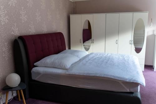 a bedroom with a bed and a white cabinet at Marburg Apartment entspannter Erwin in ruhiger Waldrandlage mit Balkon und Kamin in Marburg an der Lahn