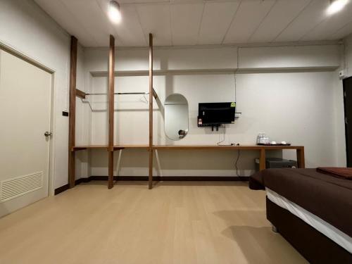 a room with a bed and a desk with a computer at theriverhouse in Ban Muang Nga