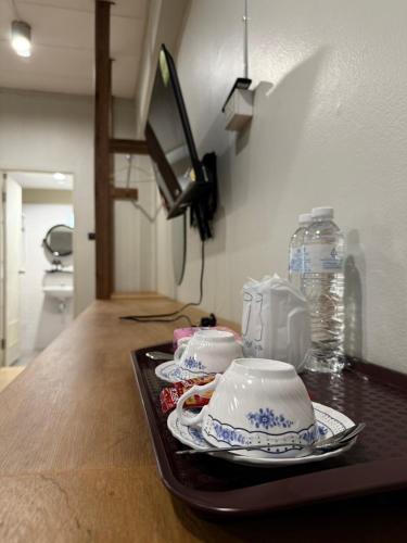 a tray with two cups and plates on a table at theriverhouse in Ban Muang Nga