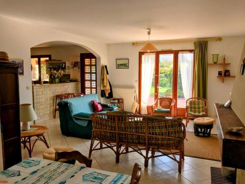 un salon avec un canapé vert et des chaises dans l'établissement La Philatelle, à Préfailles