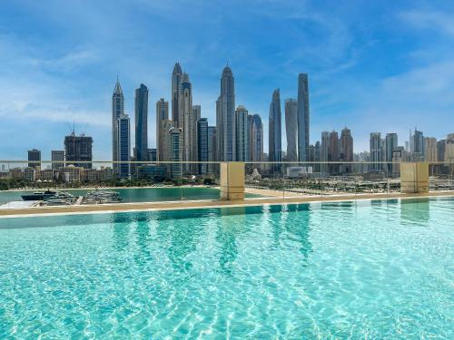 a swimming pool with a city skyline in the background at Chic 1 Bedroom on Private Beach in Dubai Harbour in Dubai
