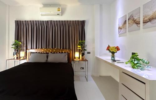 a bedroom with a black bed and a desk at Bangrak Cozy Stay in Koh Samui 