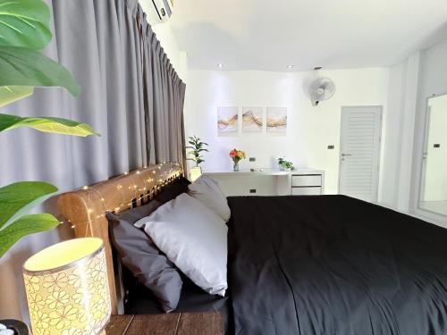 a bedroom with a bed with a black comforter at Bangrak Cozy Stay in Koh Samui 