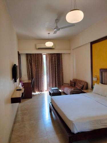 a hotel room with a bed and a couch at VITS Lonavala in Lonavala