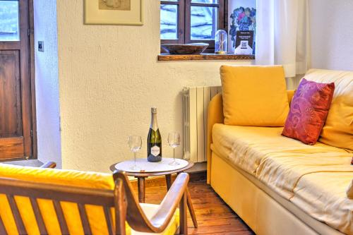 a living room with a couch and a table with wine glasses at Coeur Blanc in Verrand