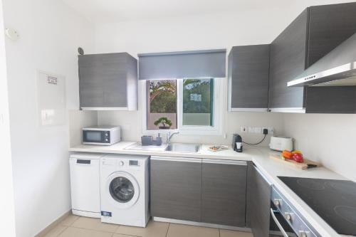 a kitchen with a washing machine and a sink at Casa de Nicole in Protaras