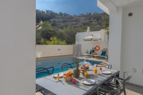 a patio with a table and a swimming pool at Casa de Nicole in Protaras