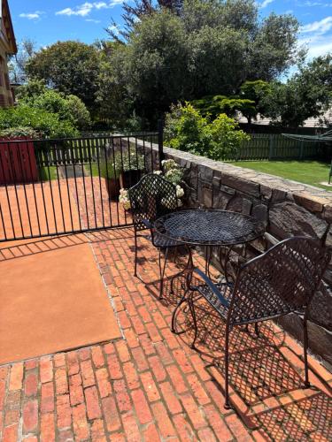 a patio with two chairs and a table and a fence at Silwood Apartment fully self contained with Kitchen and Laundry in Devonport