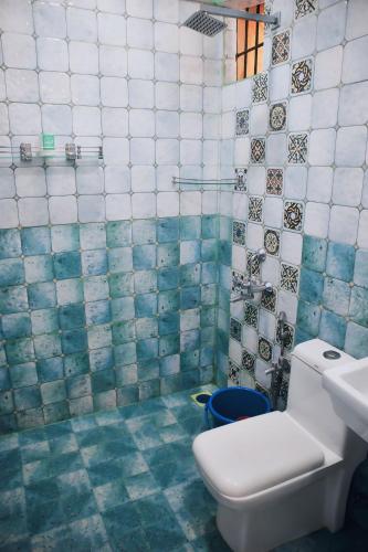 a bathroom with a toilet and a sink and tiles at House Of Brothers in Arambol