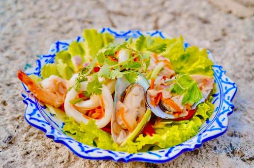 a plate of food with shrimp on top of lettuce at Happy Lagoon Bungalow in Khao Lak