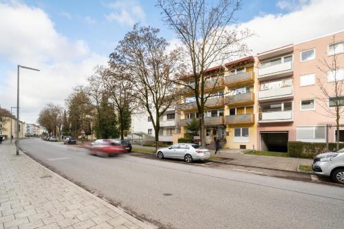 una strada con auto parcheggiate ai lati della strada di Homaris Apartments München Laim a Monaco