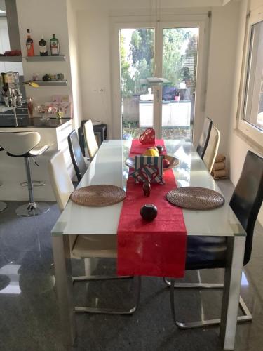 a dining room table with a red napkin on it at Chambre spacieuse, lumineuse et reposante in Oetwil an der Limmat